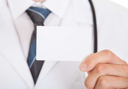 Closeup photo of doctor hand showing empty visiting cardの写真素材