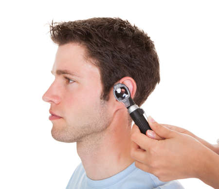 Close-up Of A Doctor Examining Patient's Ear With An Otoscope