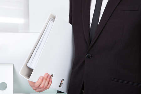 Closeup Of Businessman Holding Folder In Officeの写真素材