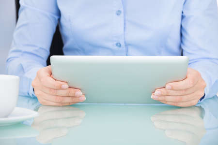 Close-up Of A Businesswoman Using Digital Tablet At Desk