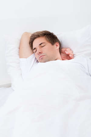 Portrait Of Young Man Sleeping In Bed