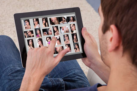 Close-up Of A Man Browsing Pictures Of Young Woman On Digital Tabletの写真素材