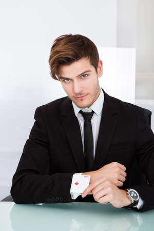 Portrait Of A Young Businessman With Playing Cards In Sleeveの写真素材