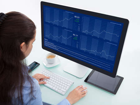 Portrait Of A Businesswoman At Desk Analyzing Graph On Computer