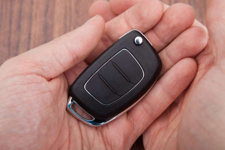Close-up Of Hand Holding Black Car Key