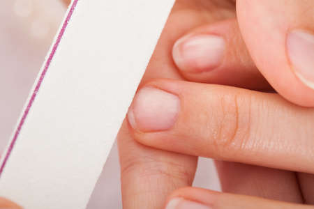 Close-up Of Beautician Hand Filing The Nails Of Woman