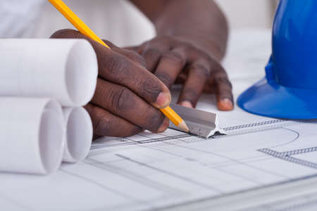 Close-up Of An African Draftsman's Hand Drawing Blueprint
