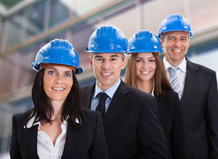 Portrait Of Happy Architects Wearing Helmet And Standing In A Row