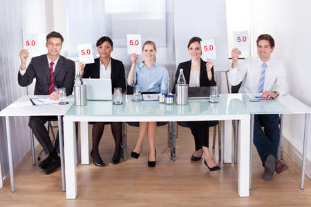 Group Of Businesspeople In Conference Holding Voting Paper