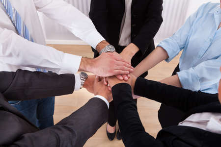 Close-up Of Businesspeople Putting Their Hands On Top Of Each Other