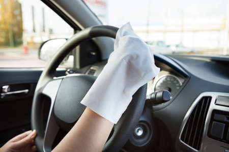 Close-up Of Hand With Glove Cleaning Steering Wheelの写真素材