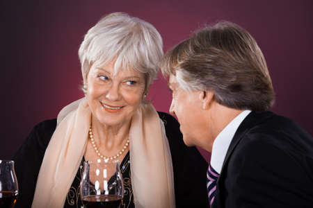 Happy Senior Couple Dining Together With Wine In A Restaurantの写真素材