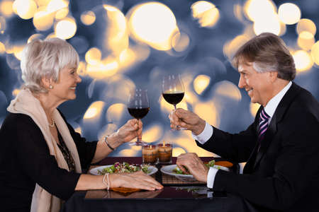 Happy Senior Couple Dining Together With Wine In A Restaurantの写真素材