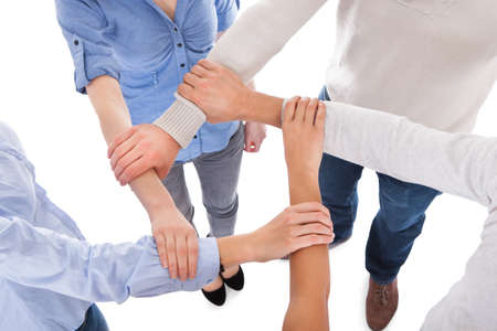 Group Of People Holding Hand Together Over White Background