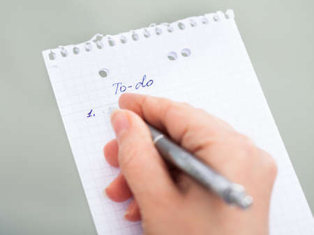 Close-up Of Hand With Pen Filling Out To Do List