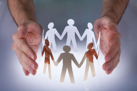 Close-up Of Hands Taking Care Of Paper Peopleの写真素材