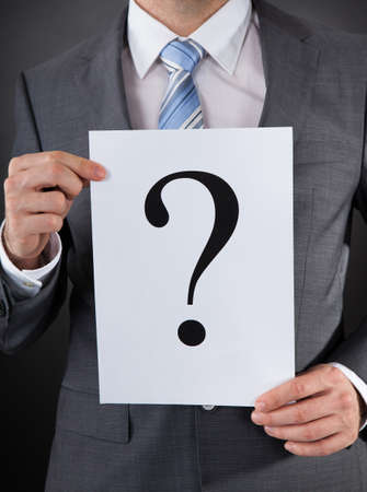 Close-up Of Businessperson Holding Board With A Question Markの写真素材