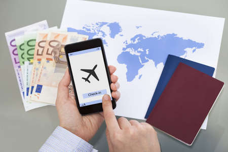 Close-up Of Hand Checking-In For A Flight Using Cellphoneの写真素材
