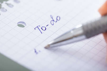 Close-up Of Hand With Pen Filling Out To Do List