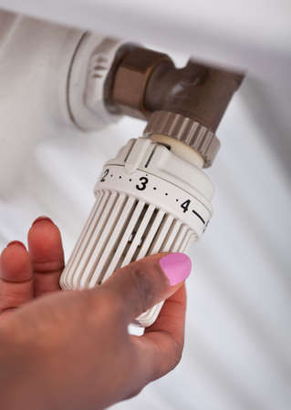 Cropped image of woman hand adjusting thermostatの写真素材