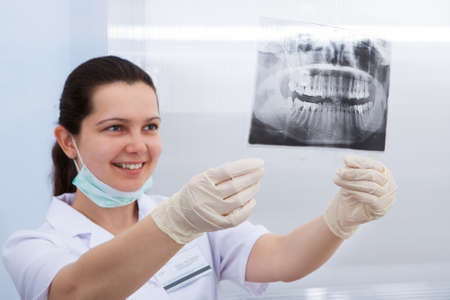 Female dentist examining dental Xray in clinic