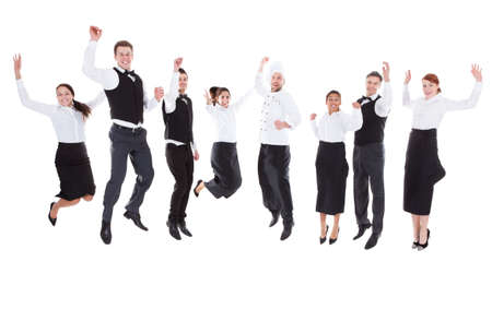Waiters and waitresses jumping over white backgroundの写真素材
