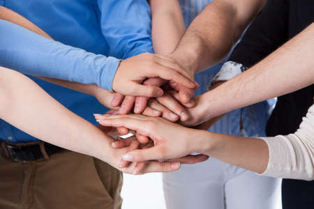 Group of people stacking hands together. Isolated on white