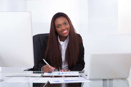 Portrait of confident businesswoman working at desk in officeの写真素材