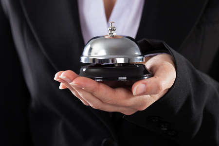 Close-up Of Business Person Holding Service Bellの写真素材