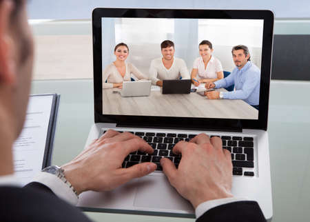 Cropped image of businessman using laptop at desk in office