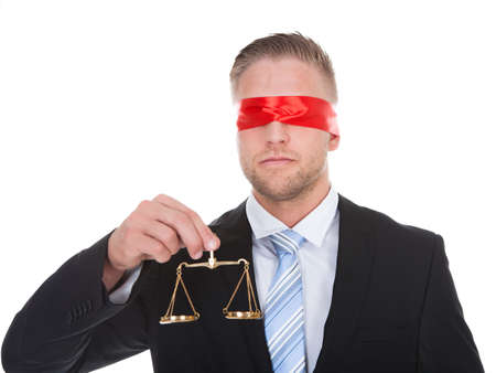 Lawyer or judge with the scales of justice in his hand wearing a blindfold  conceptual of impartiality and fairnessの写真素材