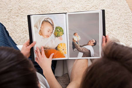 Portrait Of Couple Looking At Photo Album