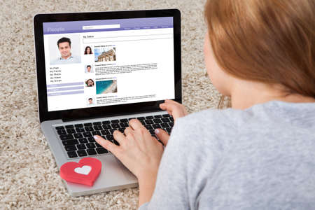 Rear View Of Woman Chatting On Social Networking Sites Using Laptopの写真素材