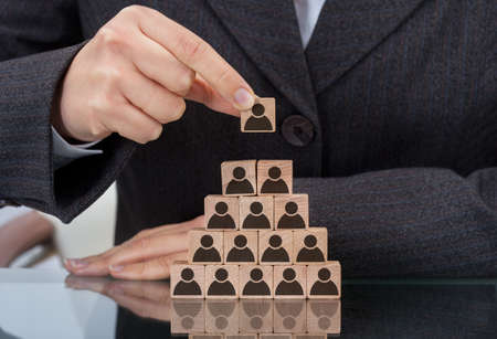 Midsection of businesswoman stacking wooden team blocks at table