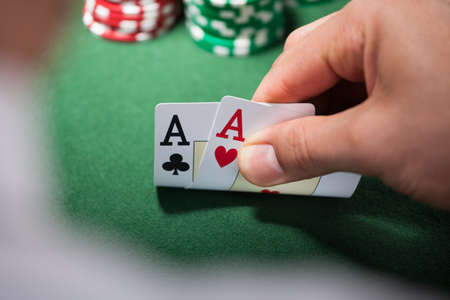 Closeup of man with two aces in casino