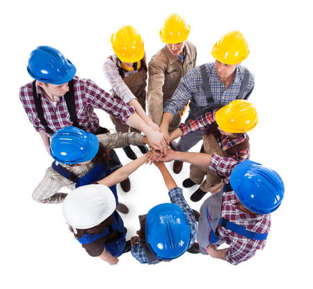 Large group of construction worker stacking hands. Isolated on white