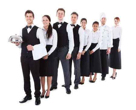 Large group of waiters and waitresses standing in row. Isolated on whiteの写真素材