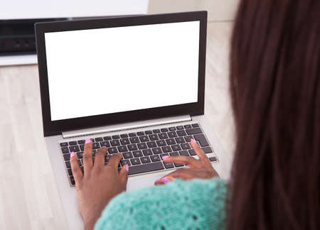 Cropped image of woman using laptop at homeの写真素材