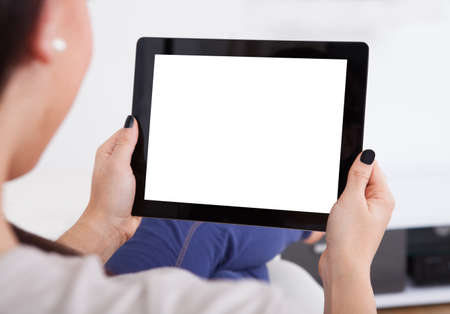 Cropped image of young woman using digital tablet at home