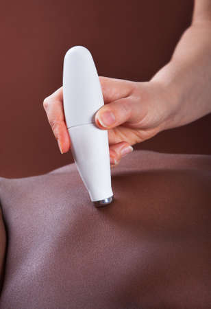 Close-up view of young African American woman undergoing microdermabrasion therapy at beauty spa
