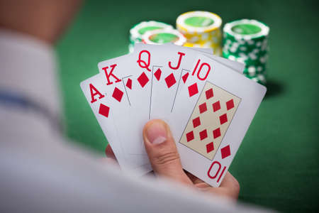 Cropped image of man playing winning hand of poker