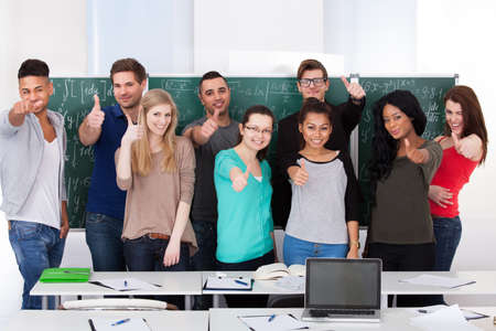 Group portrait of confident multiethnic college students standing together in classroomの写真素材