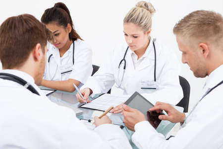 Team of doctors working at desk in clinicの写真素材