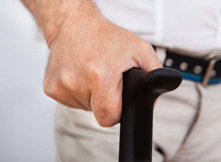 Midsection closeup of disabled senior man with walking stickの写真素材