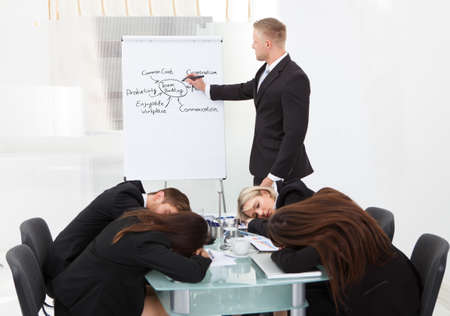 Businessman And His Colleagues Sleeping During Presentationの写真素材
