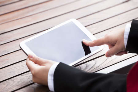 Cropped image of businesswoman holding digital tablet outdoorsの写真素材