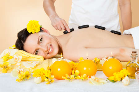 Portrait of beautiful young woman receiving hot stone therapy in spaの写真素材