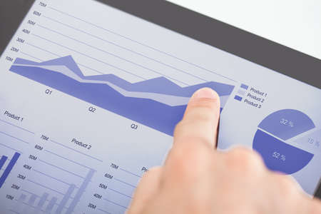 Cropped image of businessman analyzing graphs on digital tablet