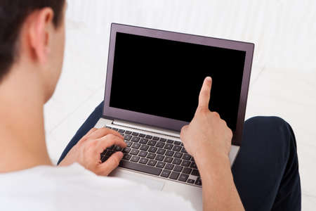 Midsection of young man using laptop at homeの写真素材