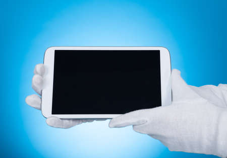 Cropped image of butler showing digital tablet over blue background